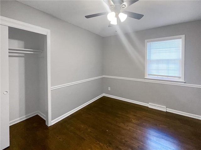 unfurnished bedroom featuring visible vents, wood finished floors, a closet, baseboards, and ceiling fan