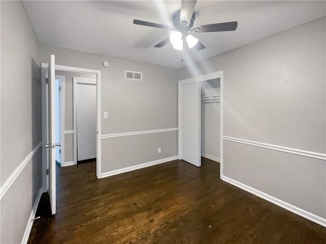 unfurnished bedroom featuring visible vents, ceiling fan, baseboards, wood finished floors, and a closet