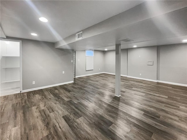 finished basement featuring visible vents, baseboards, and wood finished floors