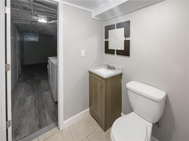 bathroom featuring baseboards, toilet, vanity, and tile patterned flooring