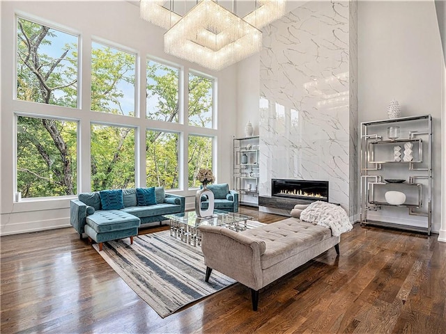 living room featuring a chandelier, a premium fireplace, and a healthy amount of sunlight