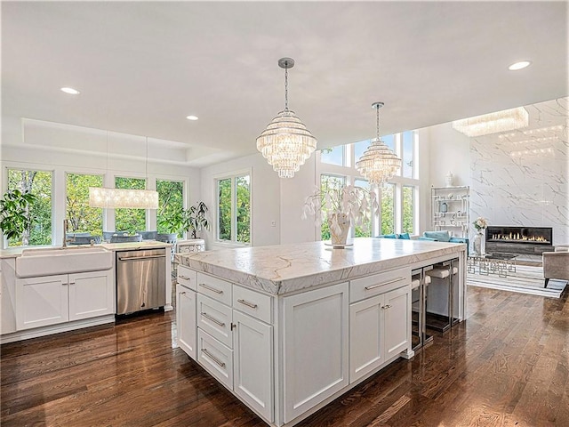 kitchen featuring white cabinetry, dark hardwood / wood-style floors, a premium fireplace, and decorative light fixtures