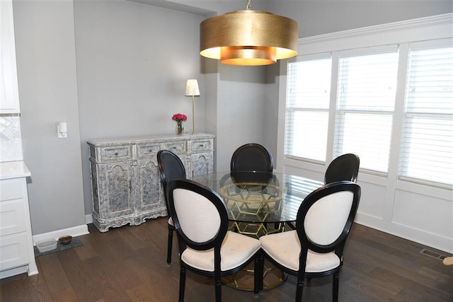 dining room with dark wood-style floors, visible vents, and baseboards