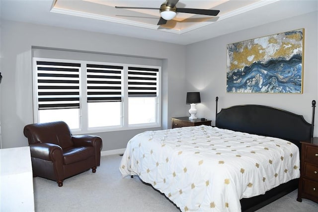 bedroom featuring baseboards, a raised ceiling, a ceiling fan, and light colored carpet