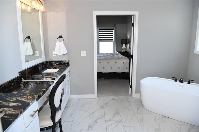 full bathroom featuring a freestanding tub, connected bathroom, a sink, baseboards, and marble finish floor