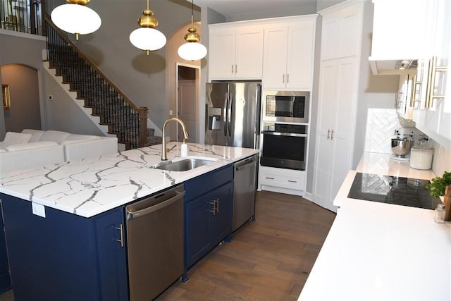 kitchen featuring dark wood-style flooring, blue cabinetry, appliances with stainless steel finishes, white cabinets, and a sink