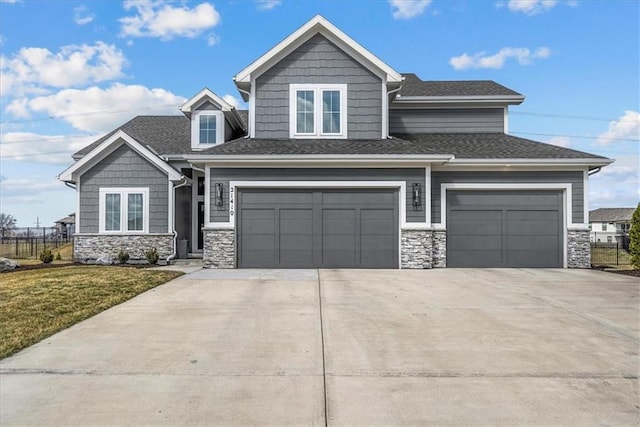 craftsman house with a shingled roof, a front yard, stone siding, and driveway