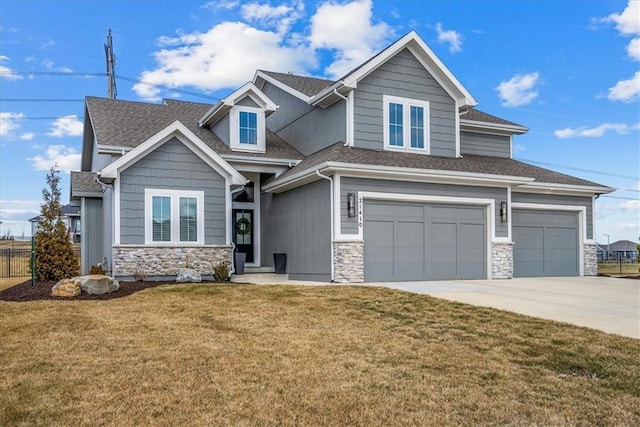 craftsman-style home with concrete driveway, an attached garage, fence, stone siding, and a front lawn