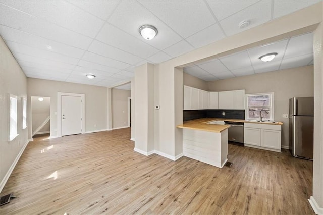 kitchen featuring light wood-style floors, white cabinetry, stainless steel appliances, and open floor plan