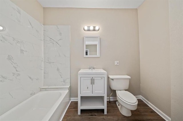 full bathroom with vanity, hardwood / wood-style floors, tiled shower / bath combo, and toilet