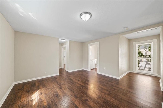 empty room featuring baseboards and wood finished floors