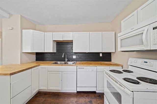 kitchen with white appliances, butcher block countertops, a sink, white cabinetry, and decorative backsplash