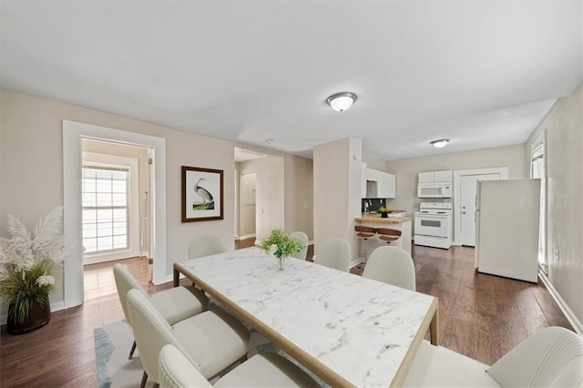 dining room with dark wood finished floors and baseboards