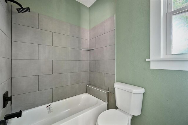 bathroom with toilet and tiled shower / bath combo