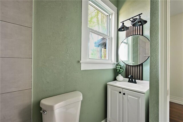 bathroom featuring vanity, toilet, and hardwood / wood-style floors