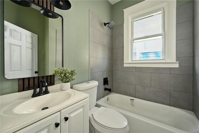 full bathroom featuring vanity, toilet, and tiled shower / bath combo