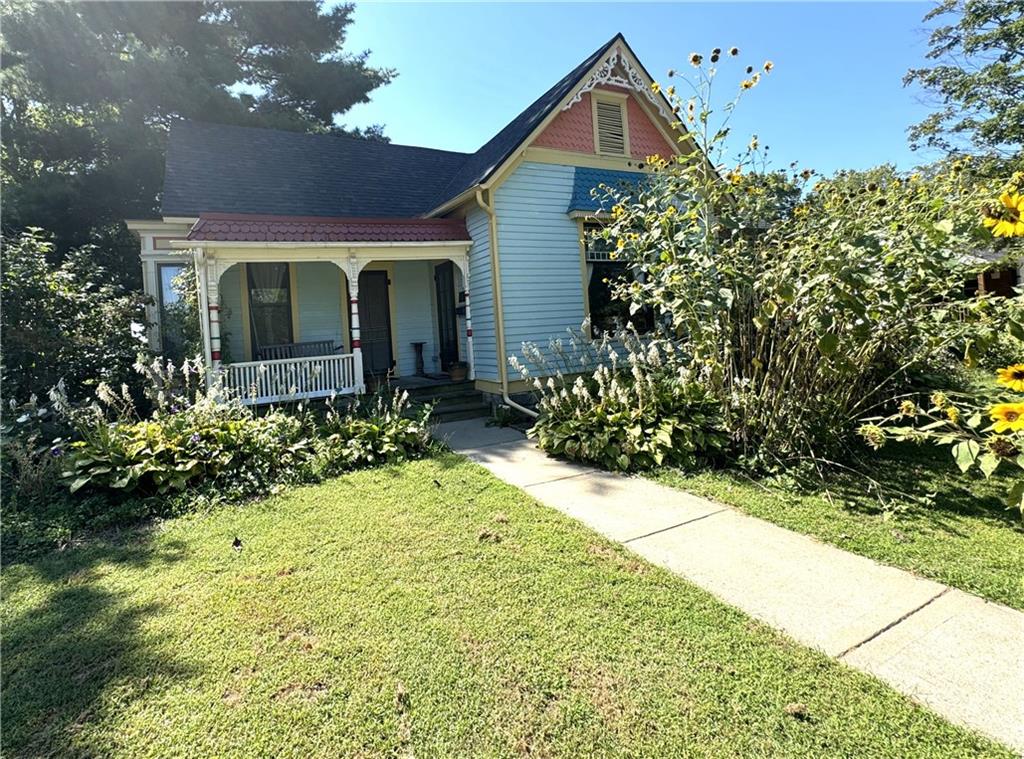 view of front of home featuring covered porch and a front lawn