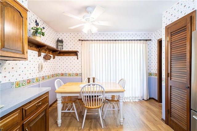 dining space with light wood-type flooring and ceiling fan