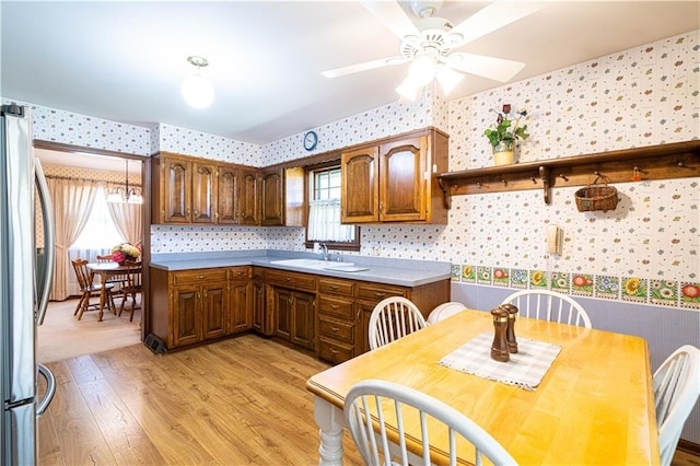 kitchen with stainless steel fridge, light hardwood / wood-style flooring, sink, and ceiling fan