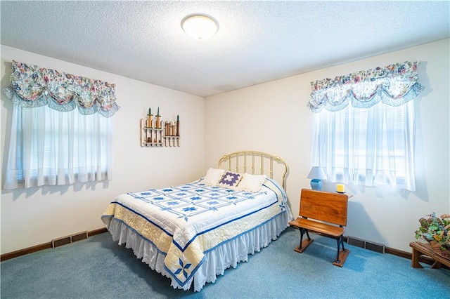 carpeted bedroom with multiple windows and a textured ceiling