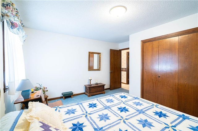 carpeted bedroom featuring a textured ceiling and a closet