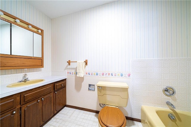 bathroom featuring a tub to relax in, vanity, toilet, and tile patterned flooring