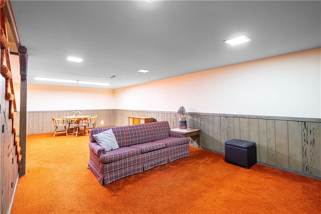 living room featuring wood walls and carpet