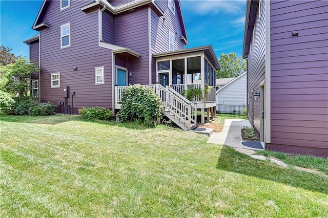 back of property with a sunroom and a yard