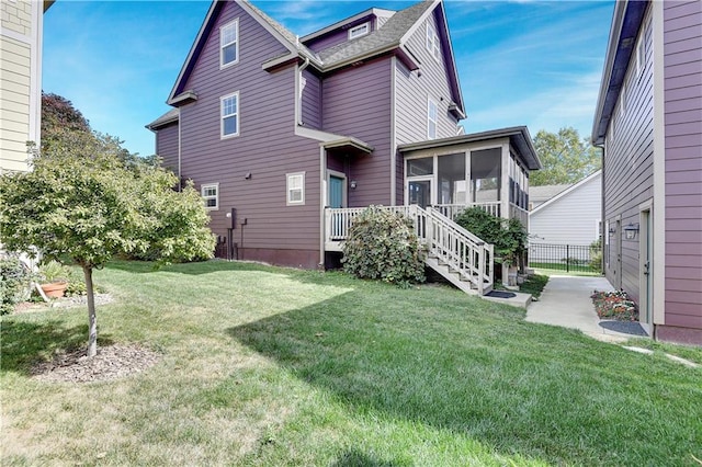 back of property featuring a lawn and a sunroom