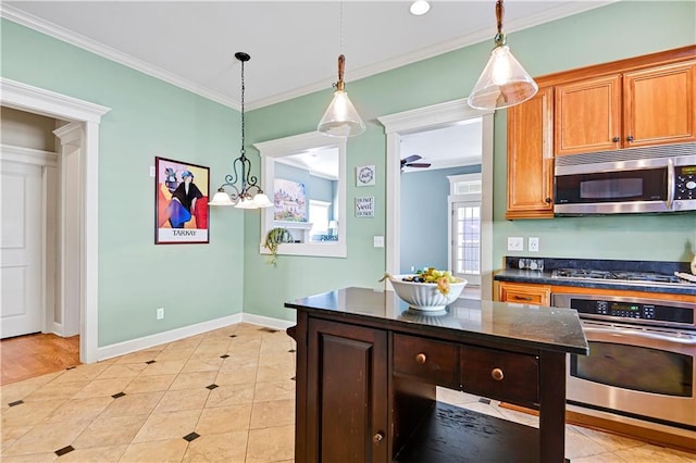 kitchen featuring pendant lighting, ceiling fan with notable chandelier, stainless steel appliances, and crown molding