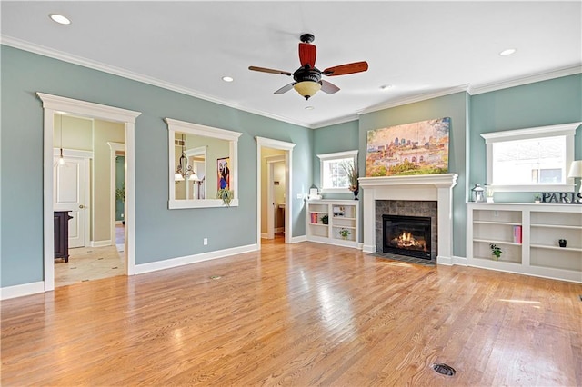 unfurnished living room with a fireplace, ceiling fan, light hardwood / wood-style flooring, and crown molding