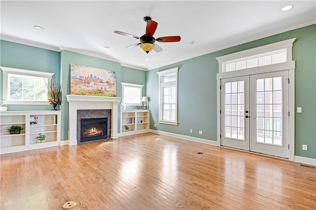 unfurnished living room featuring french doors, light hardwood / wood-style flooring, plenty of natural light, and ceiling fan