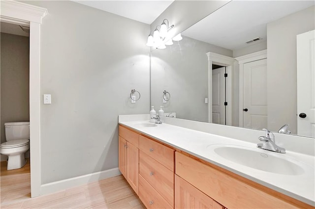 bathroom featuring wood-type flooring, vanity, and toilet