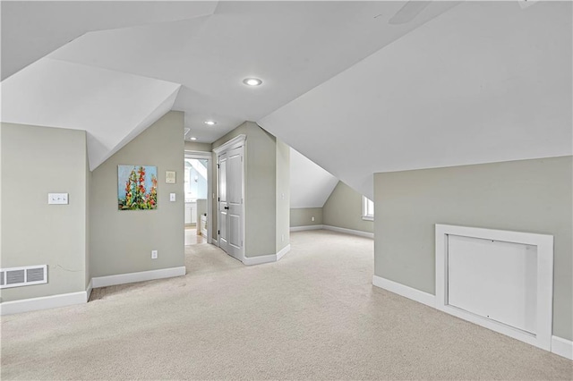 additional living space with light colored carpet and lofted ceiling