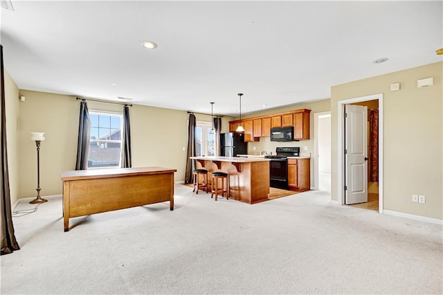 kitchen featuring a kitchen bar, light carpet, black appliances, pendant lighting, and a center island