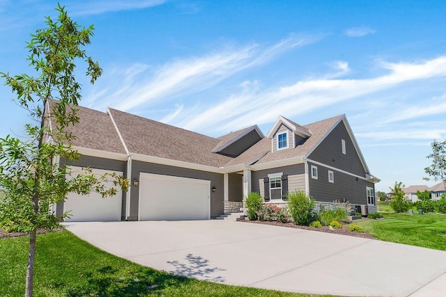 view of front of home with a garage, concrete driveway, and a front lawn