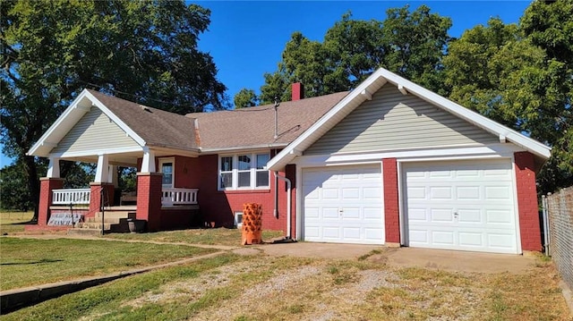 single story home with a garage, covered porch, and a front yard