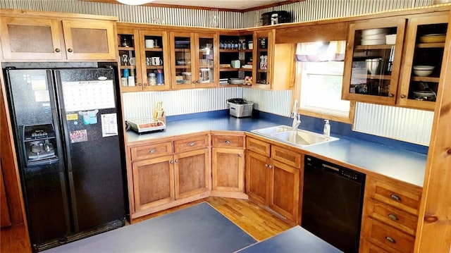 kitchen with black appliances, sink, and light wood-type flooring