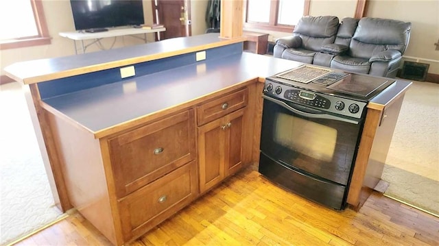 kitchen with electric range, kitchen peninsula, and light hardwood / wood-style flooring