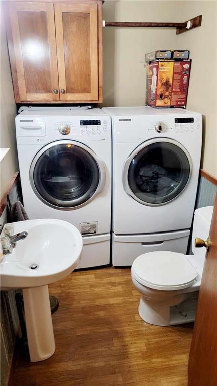 washroom featuring light wood-type flooring and washing machine and dryer