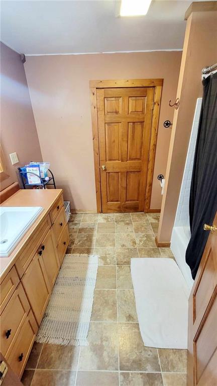 bathroom featuring shower / tub combo and vanity