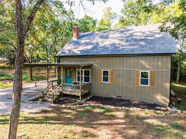 rustic home featuring crawl space, an attached carport, a chimney, and a shingled roof