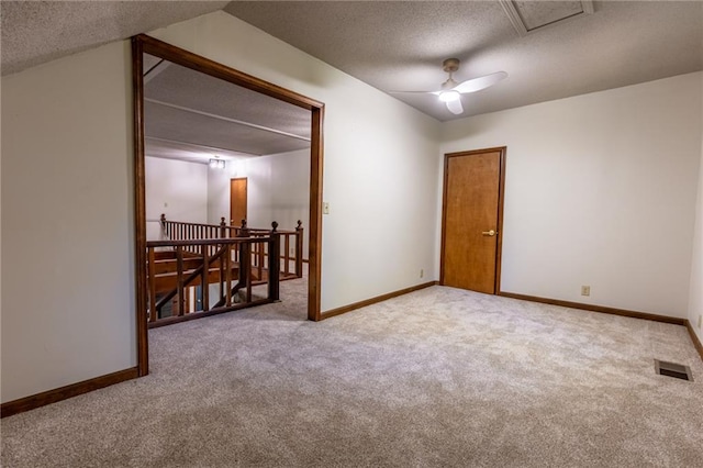 unfurnished room featuring a textured ceiling, carpet, ceiling fan, and lofted ceiling