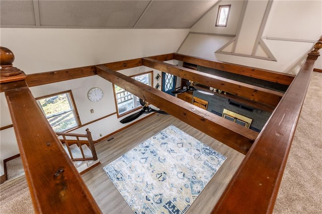 living room featuring light wood-type flooring, vaulted ceiling, and a fireplace