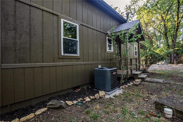 view of home's exterior featuring central air condition unit and roof with shingles