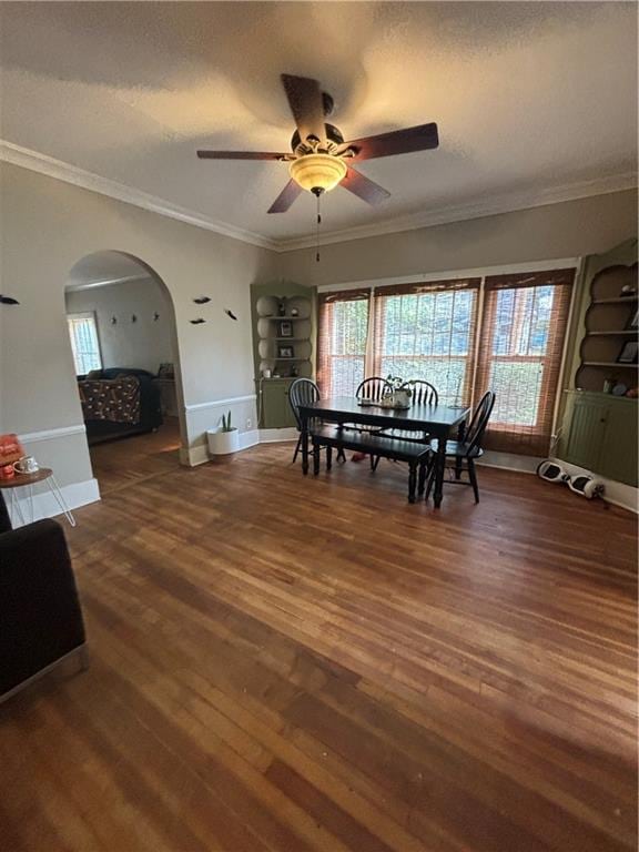 dining room featuring ceiling fan, ornamental molding, and dark wood-type flooring