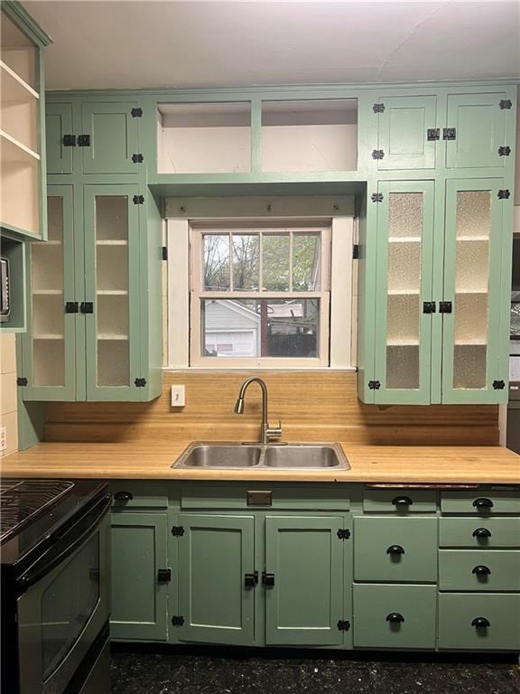 kitchen with open shelves, a sink, and green cabinets