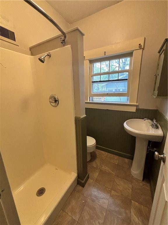 full bath with a shower stall, toilet, a sink, and visible vents