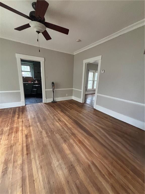 spare room featuring hardwood / wood-style floors, a ceiling fan, a healthy amount of sunlight, and crown molding