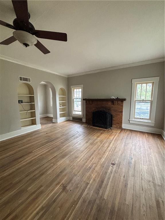 unfurnished living room featuring baseboards, built in features, wood finished floors, and visible vents